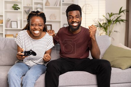 Photo for Couple Enjoying Video Game Together On Couch At Home, Competitive Fun, Leisure Activity - Royalty Free Image