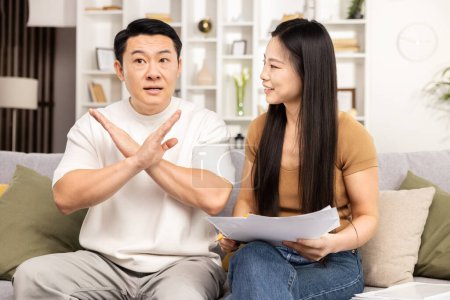 Photo for Family discussion, indoor setting with Asian adult daughter and father showing refusal or objection gesture, communication concept - Royalty Free Image