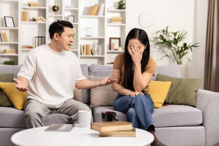 Couple Argument At Home, Man Gesticulating To Distressed Woman On Couch, Emotional Discussion, Family Conflict, Indoor Stressful Conversation, Relationship Issues
