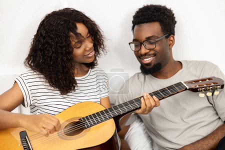Photo for Happy couple Playing Guitar Together At Home, Casual Leisure, Music Hobby, Smiling, African Americans - Royalty Free Image