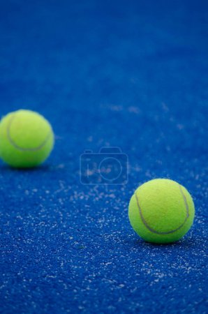 Téléchargez les photos : Mise au point sélective, deux balles sur un court de paddle tennis bleu - en image libre de droit