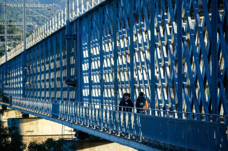 Foto de Dos peregrinos a Santiago de Compostela cruzando el puente internacional sobre el río Minho entre Tui y Valenca do Minho desde el lado portugués. - Imagen libre de derechos