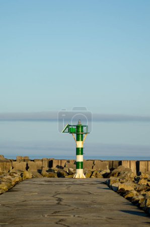 Téléchargez les photos : Lanterne verte et blanche au bord d'un brise-lames - en image libre de droit