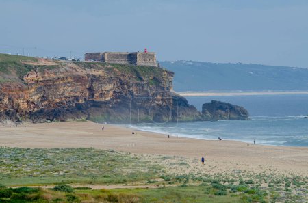 Foto de Playa de Praia do Norte, acantilados y cabo del faro nazarí. Portugal. - Imagen libre de derechos