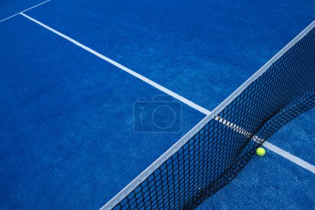 Téléchargez les photos : Vue surélevée sur le filet d'un court de paddle tennis bleu et d'une balle. Sports de raquette - en image libre de droit