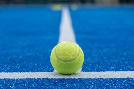 Foto de Enfoque selectivo de una pelota de pádel en la línea de una pista de pádel azul, deportes de raqueta - Imagen libre de derechos