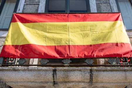 Téléchargez les photos : Drapeau espagnol accroché sur le balcon d'une maison en Espagne. - en image libre de droit