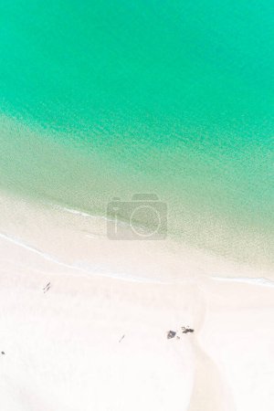 Overhead drone view of the shore of a turquoise water beach in Portugal