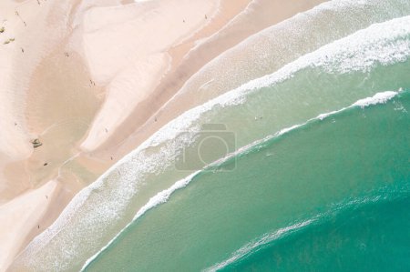 Beach with people enjoying the summer as seen from a drone, zenithal shot