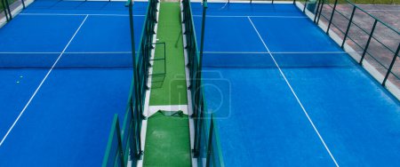 two blue synthetic grass paddle tennis courts, racket sports concept