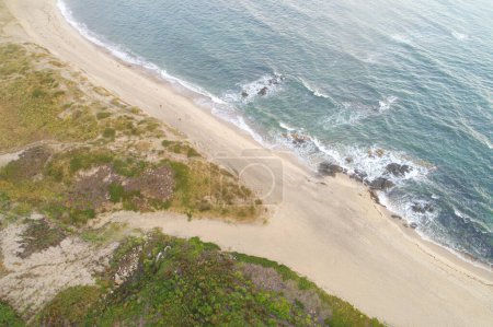 vista aérea de tres personas paseando por una playa vacía, concepto de hora de verano