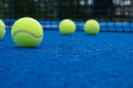 Selective focus, five balls on a paddle tennis court