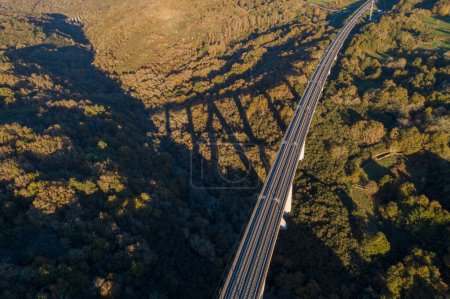 vista aérea del dron de una línea de ferrocarril de alta velocidad en un puente al atardecer