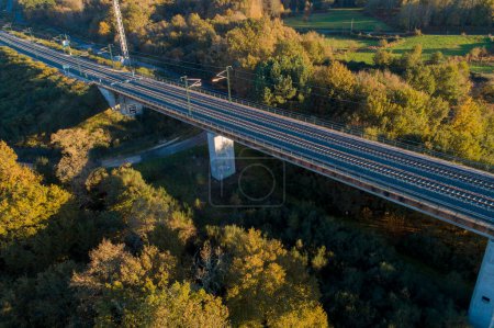 drone aerial view of a high speed railway bridge at sunset