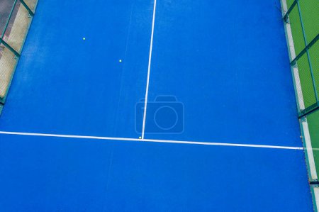 drone aerial view of a blue paddle tennis court with balls