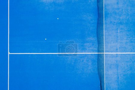 aerial view of a blue paddle tennis court with balls