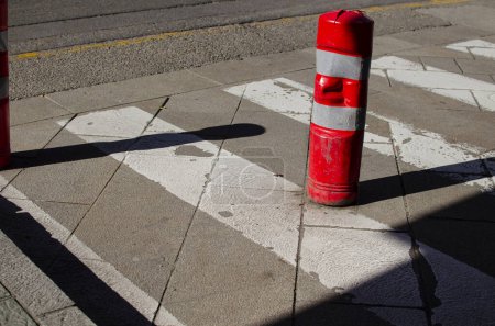 red plastic bollard to prevent parking the car in a pedestrian crossing
