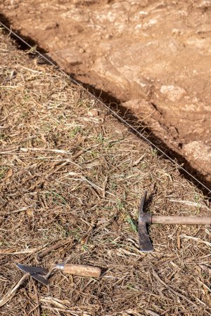 Pickaxe and trowel at an archaeological excavation