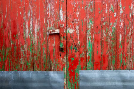 detail of an antique wooden door painted green and red