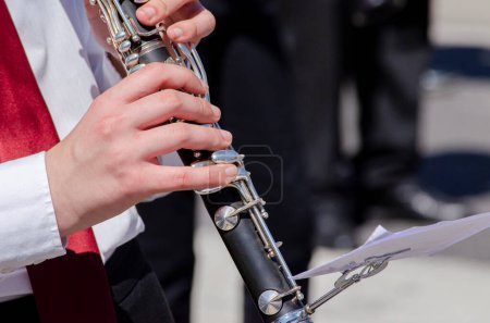 close-up view of a girl's hands playing the clarinet