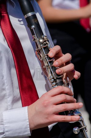 vue rapprochée des mains d'une fille jouant de la clarinette, apprentissage de la musique