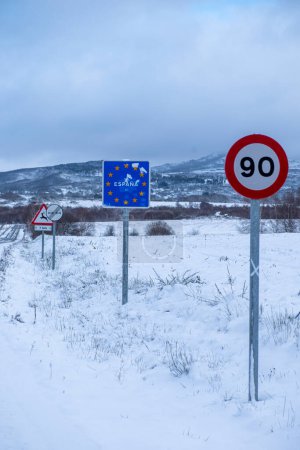Traffic signs at the Portuguese border on a snowy day