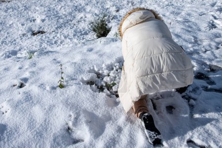 una chica irreconocible jugando en la nieve. Invierno divertido concepto