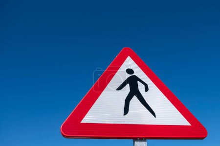 Traffic sign, pedestrian crossing danger over a blue sky