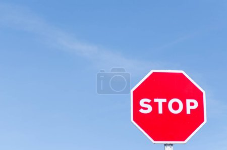 isolated stop sign with blue sky in the background