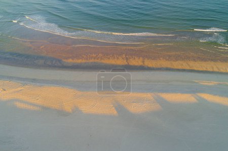 drone aerial view of a beach and the sea at dawn during golden hour. Summer concept