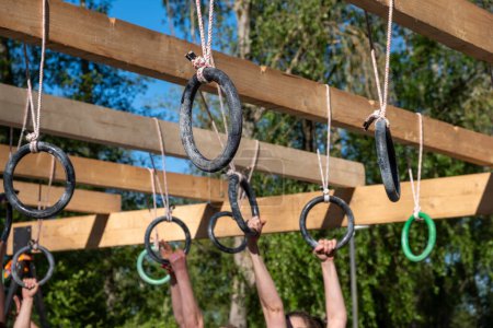 selective focus, athletes hands at a hanging obstacle at an obstacle course race, OCR