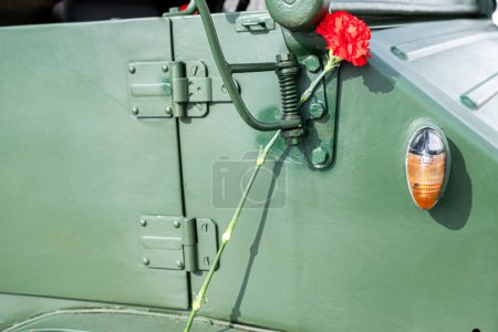 a red carnation decorating a military vehicle during the commemoration of April 25th in Portugal. Carnation revolution. Liberty freedom