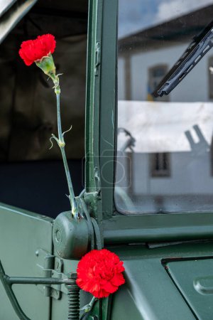 two red carnations decorating a military vehicle during the commemoration of April 25th in Portugal. Carnation revolution