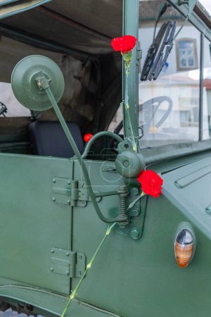 two red carnations decorating a military vehicle during the celebration of the 25th of April in Portugal. Carnation revolution.