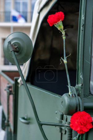 two red carnations decorating a military vehicle during the commemoration of April 25th in Portugal. Carnation Revolution