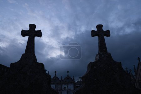 silhouette of grave crosses in a catholic cemetery at sunset