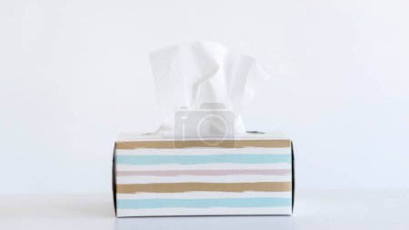 Foto de Caja de pañuelos de color claro sobre fondo blanco. Concepto de resfriado y gripe. - Imagen libre de derechos