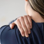 Rear view shot of a woman suffering from a shoulder pain