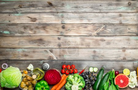 Organic food. Assortment of fresh fruits and vegetables. On a wooden background.