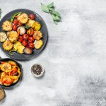 Various grilled vegetables with spices and herbs. On a rustic background.