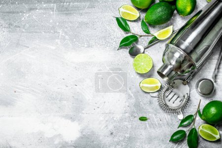 Shaker with pieces of juicy lime and leaves. On rustic background