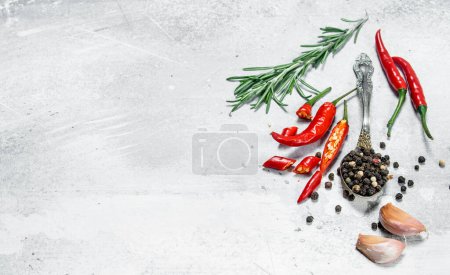 Pepper peas in a spoon with pieces of red pepper, rosemary and garlic. On rustic background