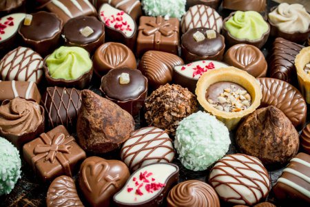 Téléchargez les photos : Bonbons au chocolat avec des noix et diverses garnitures. Concentration sélective
. - en image libre de droit