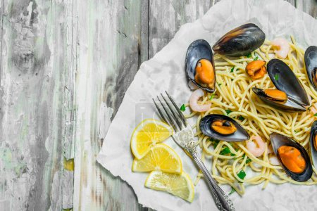 Foto de Pastas mediterráneas. Espaguetis mariscos con almejas sobre papel. Sobre un fondo rústico
. - Imagen libre de derechos