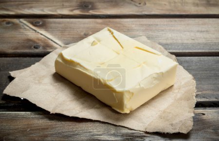 Photo for Butter on old paper. On a wooden background. - Royalty Free Image