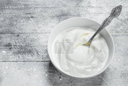 Sour cream in bowl . On a rustic background.