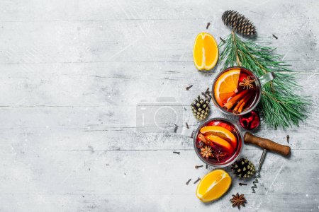 Photo for Mulled wine with spices and orange slices. On a rustic background. - Royalty Free Image