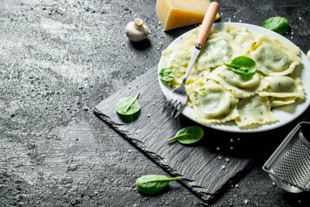 Photo for Fragrant ravioli with Parmesan and herbs. On black rustic background - Royalty Free Image