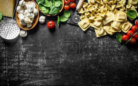 Photo for Different kinds of Italian raw pasta with tomatoes and spinach. On dark rustic background - Royalty Free Image