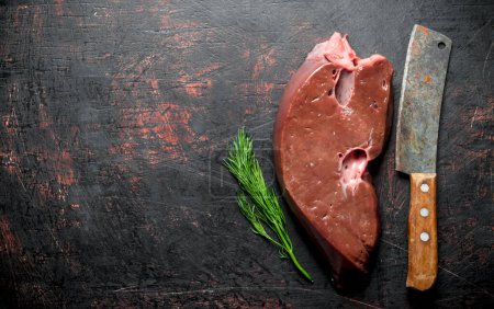 Téléchargez les photos : Foie cru avec couteau et aneth. Sur fond rustique sombre - en image libre de droit